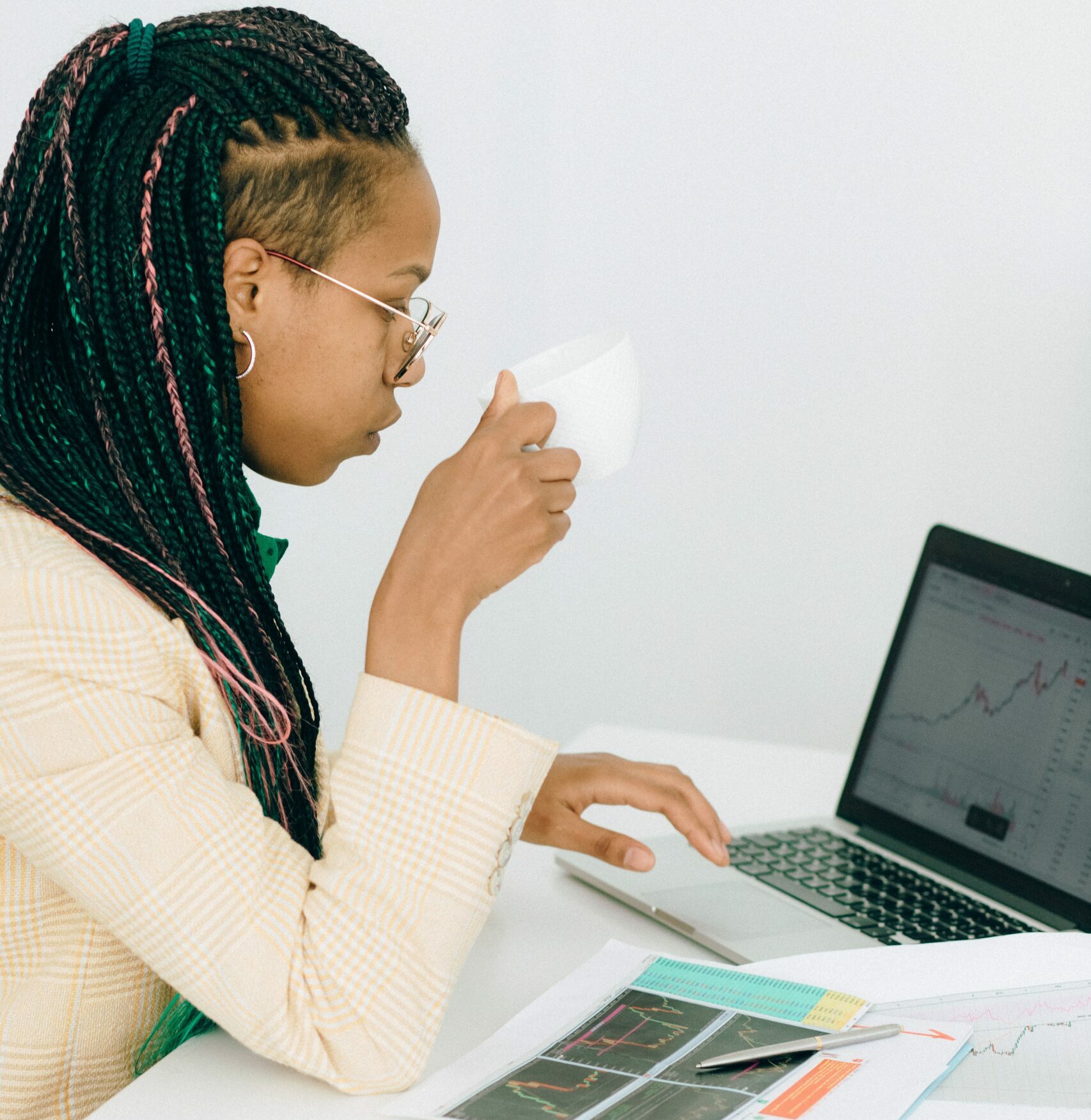 junge Frau sitz am Lapto mit einer Tasse in der Hand